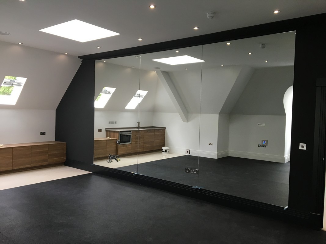 Frameless glass wall dividing loft conversion in Friern Barnet